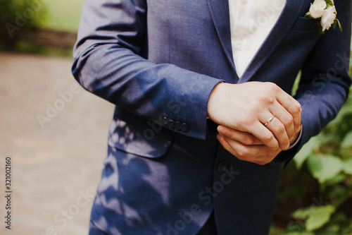 the groom adjusts his jacket