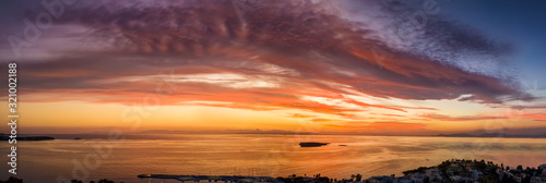 Panorama eines Sonnenunterganges   ber dem Meer mit roten und violetten Farben