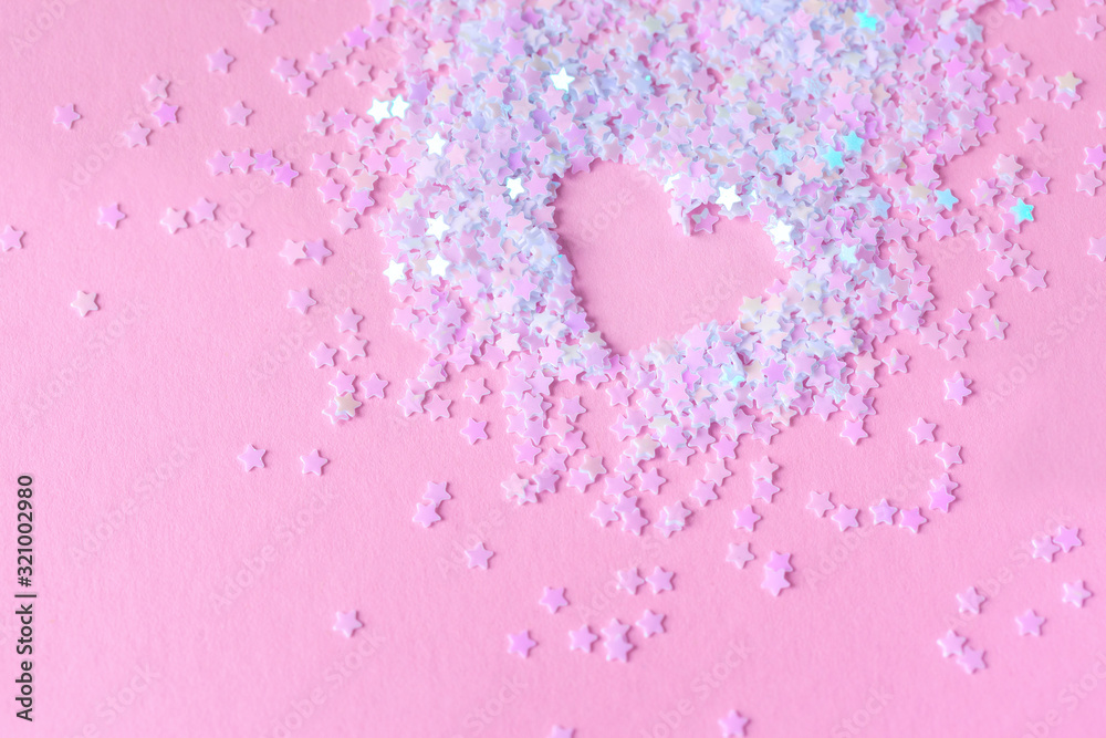 Heart made of white stars confetti on pink background. Love concept.