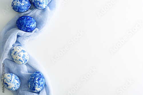 six Easter eggs in the color of the year-classic blue with gradient effect on soft blue fabric and white background