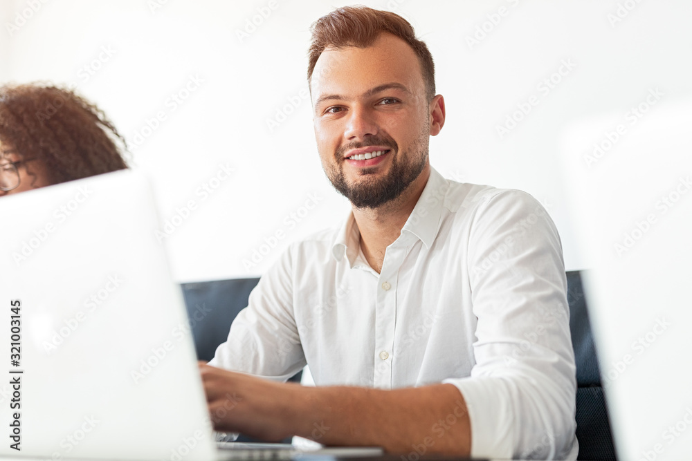 Office employee with laptop smiling for camera Office employee with laptop smiling for camera
