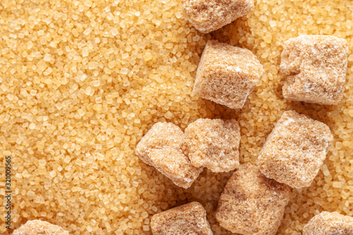 Сane brown sugar. Background from crystals and pieces of sugar. Сlose-up