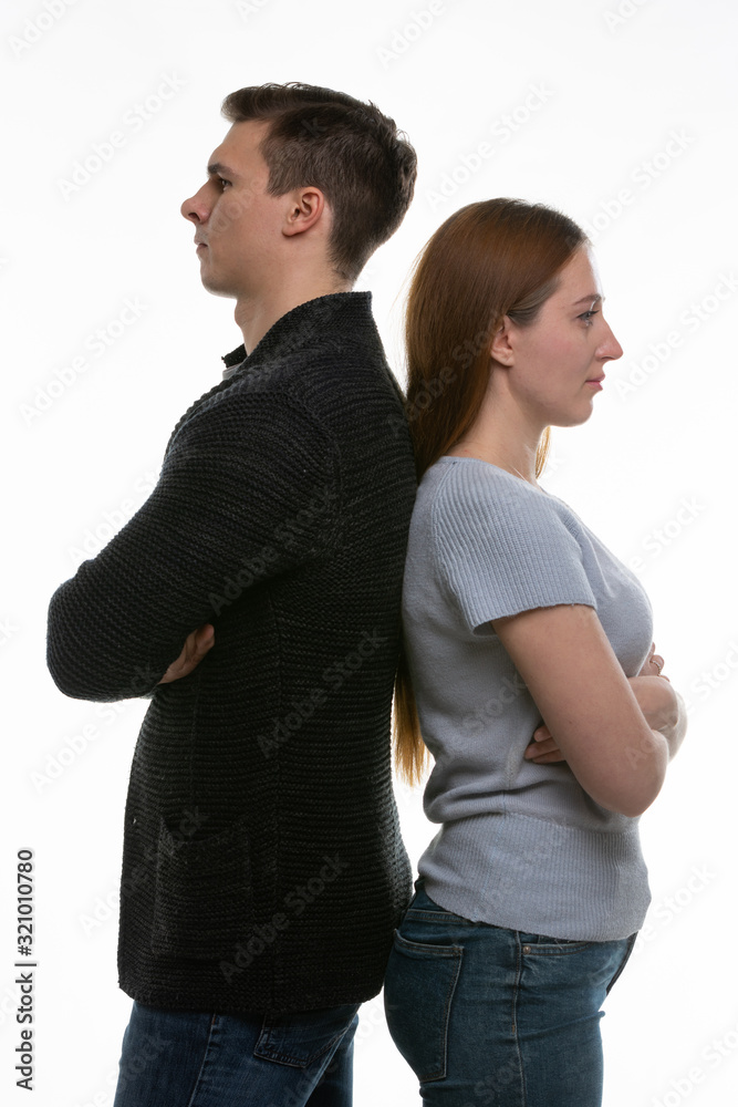 A man and a woman stand with their backs to each other, with their arms folded on their chests A man and a woman stand with their backs to each other, with their arms folded on their chests