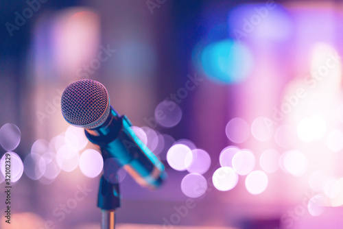Close up of high fidelity microphone setting on stand with colorful abstract light bokeh background in conference seminar hall . Microphone on stage banner size. photo