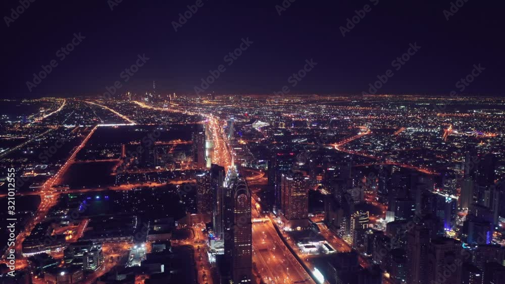 Aerial night illuminated Dubai city skyline skyscrapers view and  busy traffic on Sheikh Zayed road  highway