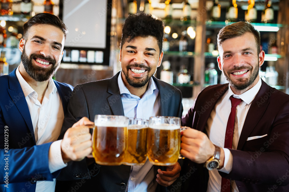 Group of happy friends drinking beer at the pub and having fun