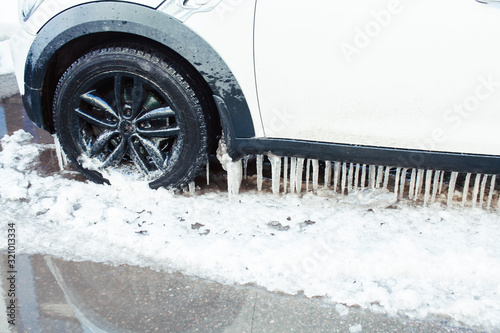 close up photo off car in iciles, a lot of water and snow, seasonal issues concept photo