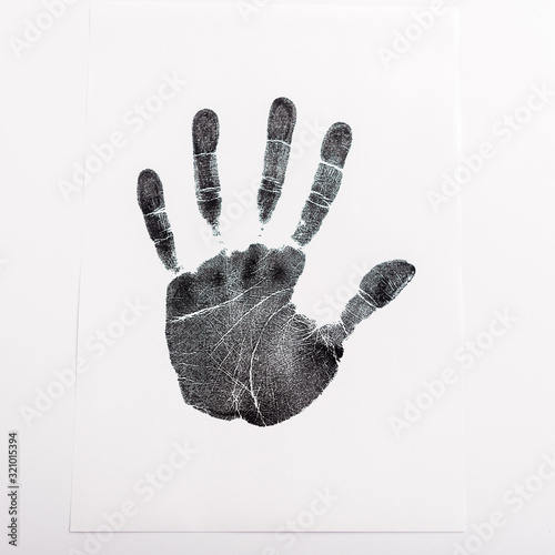 Fotografie Top view of black print of hand on paper isolated on white, human rights concept