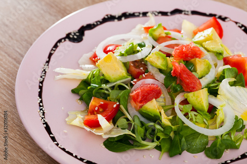 Salad of  avocado, tomatoes, grapefruit and corn salad at plate