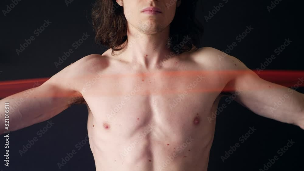 A strong shirtless white man training his arm tricep muscles with a resistance band workout in the gym SLOW MOTION. A strong shirtless white man training his arm tricep muscles with a resistance band workout in the gym SLOW MOTION.