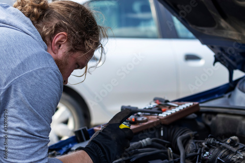 A man repairs a car himself