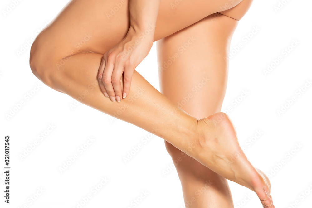 woman massaging her painful leg on white
