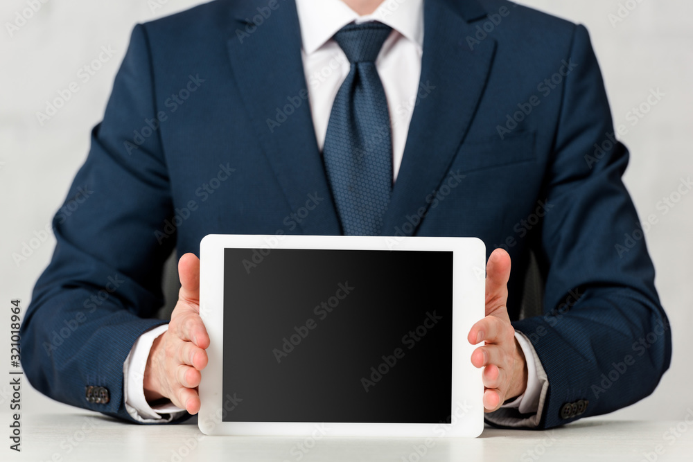 cropped view of businessman in suit holding digital tablet with blank screen on white cropped view of businessman in suit holding digital tablet with blank screen on white