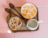 Fresh coffee and juice ready to be served on wooden tray with wooden spoons