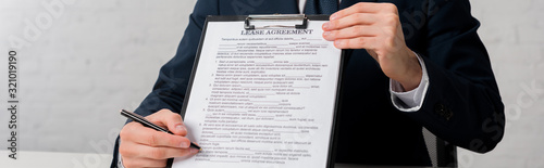 panoramic shot of realtor holding clipboard with lease agreement lettering on white