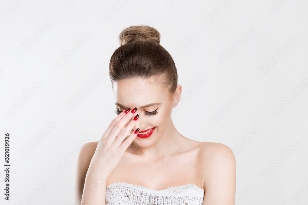 Beautiful woman smiling hand on face isolated white grey wall background. Happiness concept. Horizontal image. Red lips and nails, full makeup beautiful happy woman Beautiful woman smiling hand on face isolated white grey wall background. Happiness concept. Horizontal image. Red lips and nails, full makeup beautiful happy woman