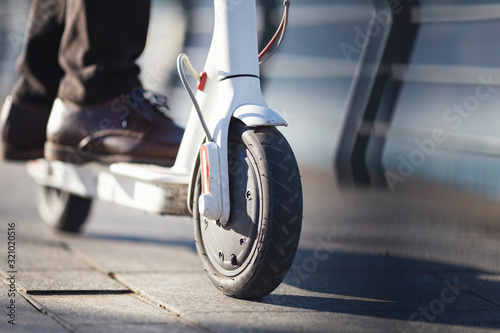 Young businessman on e scooter in the city photo