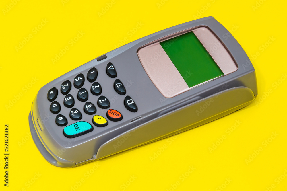 Business still life payment terminal for receiving money on yellow office desk Business still life payment terminal for receiving money on yellow office desk