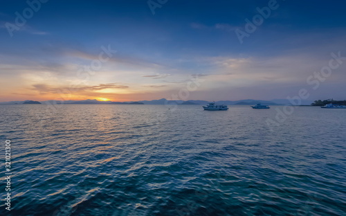 view panorama morning of the boats floating in the sea with red sun light and blue sky background  sunrise at front beach  Ko Phayam  ko payam  island  Ranong  southern of Thailand.