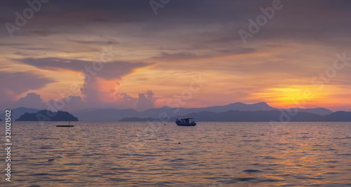 Sea view panorama morning of fishing boat running in the sea with purple sky background  sunrise at front beach  Ko Phayam island  Ranong Province  southern of Thailand.