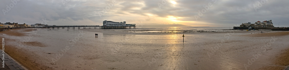 Weston-super-Mare, UK - December 26, 2019: The Grand Pier is a pleasure pier on the Bristol Channel approximately 18 miles southwest of Bristol. Winter view with low tide and cloudy weather Weston-super-Mare, UK - December 26, 2019: The Grand Pier is a pleasure pier on the Bristol Channel approximately 18 miles southwest of Bristol. Winter view with low tide and cloudy weather