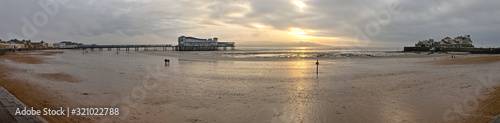Weston-super-Mare, UK - December 26, 2019: The Grand Pier is a pleasure pier on the Bristol Channel approximately 18 miles southwest of Bristol. Winter view with low tide and cloudy weather