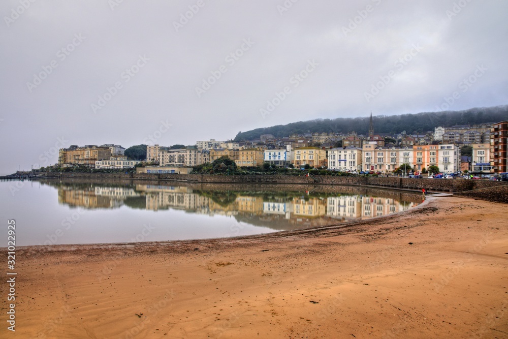 Weston-super-Mare, UK - December 26, 2019: Panoramic winter view of Weston coastline in low tide, cloudy sky and muddy beaches