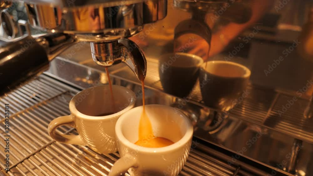 Coffee machine making a cappuccino and espresso hot drink in cafe bar at the morning
