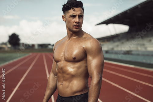 Canvastavla Muscular man relaxing after a run on the track