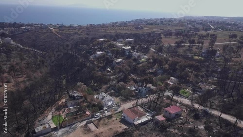 Aerial photography of the aftermath of 2018 Attica wildfires in Athens of Greece; dry trees and town photo