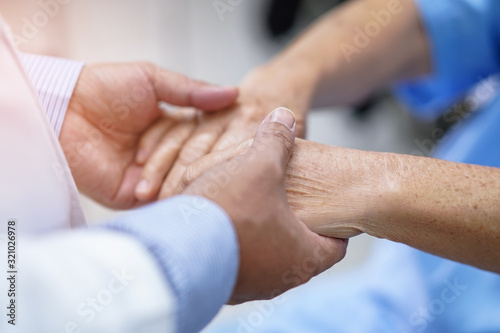 Doctor holding hands Asian senior or elderly old lady woman patient with love, care, encourage and empathy at nursing hospital ward : healthy strong medical concept