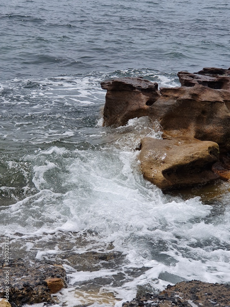 Fototapeta premium waves crashing on rocks