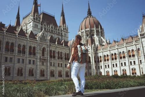Photography Back view of Tourist girl looking on Budapest parliament view, Hungary