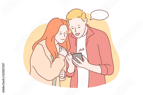 Communication, social media or network concept. Young couple in love communicates in social network. Man and woman watch videos in social media. Boyfriend and girlfriend type messages in smartphone.
