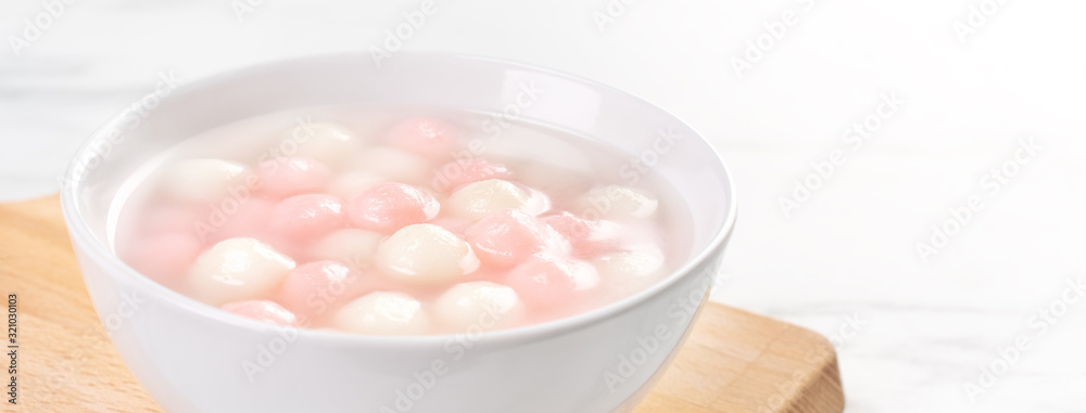 Tang yuan, tangyuan, delicious red and white rice dumpling balls in a small bowl. Asian traditional festive food for Chinese Winter Solstice Festival, close up. Tang yuan, tangyuan, delicious red and white rice dumpling balls in a small bowl. Asian traditional festive food for Chinese Winter Solstice Festival, close up.