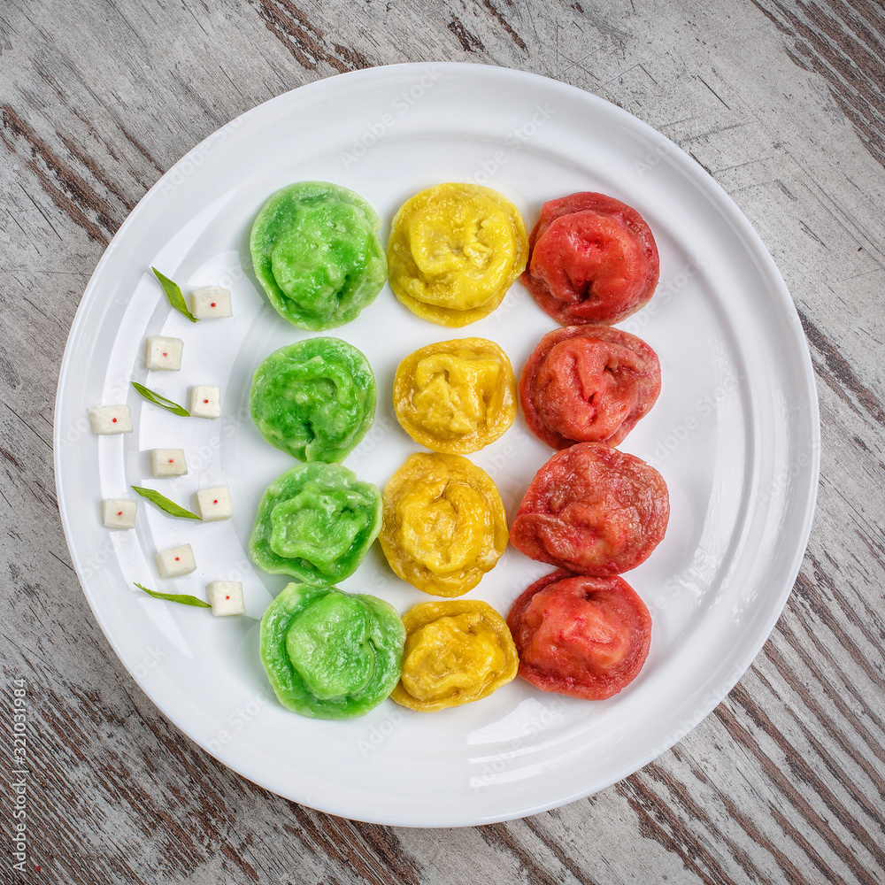 Colored green, red and yellow raviolion the plate Colored green, red and yellow raviolion the plate