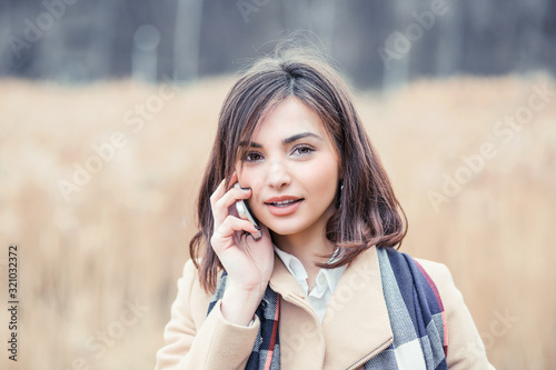 Portrait happy smiling woman talking on mobile cell phone standing outdoor near university park. Business woman having conversation on cellphone isolated outside background. Communication concept