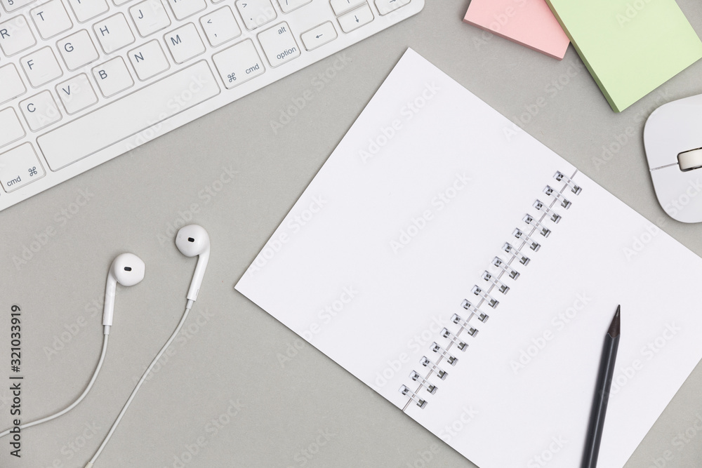 Workplace with blank notepad, keyboard and supplies on gray background. Top view. Flat lay Workplace with blank notepad, keyboard and supplies on gray background. Top view. Flat lay