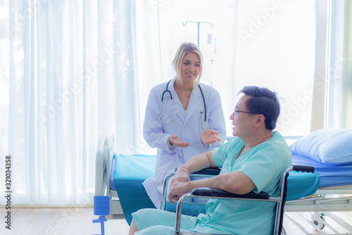 Nurse reassuring her patient on wheelchair in hospital / healthcare medical concept. copy space