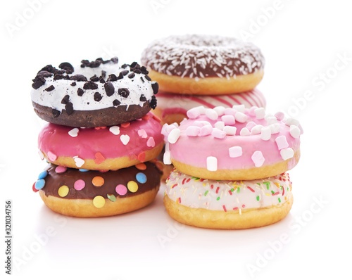 Stack of glazed doughnuts with sprinkles on white