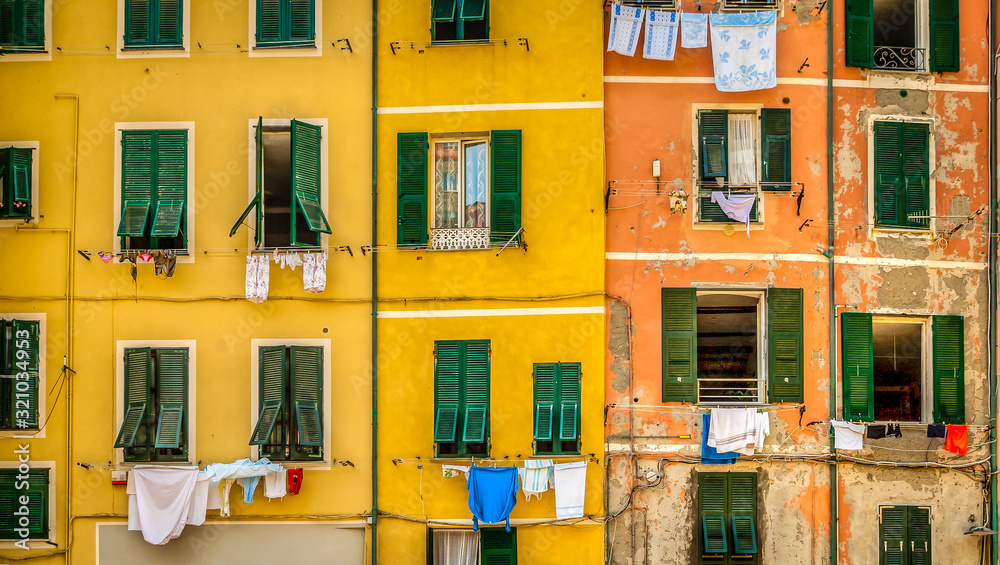 Picturesque colorful building facade with peeling paint and colorful clothes lines in the fishing village of Vernazza.