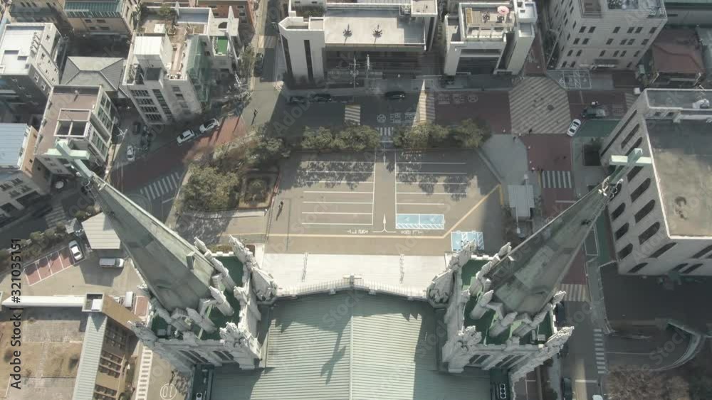 top view of the spiers of the old Catholic church in Seoul, Autumn day in a modern metropolis, near the building there is a parking for cars top view of the spiers of the old Catholic church in Seoul, Autumn day in a modern metropolis, near the building there is a parking for cars