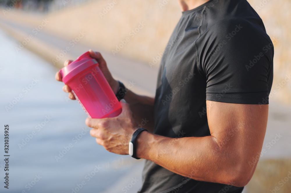 Man with fitness tracker holding a shaker. Man with fitness tracker holding a shaker.