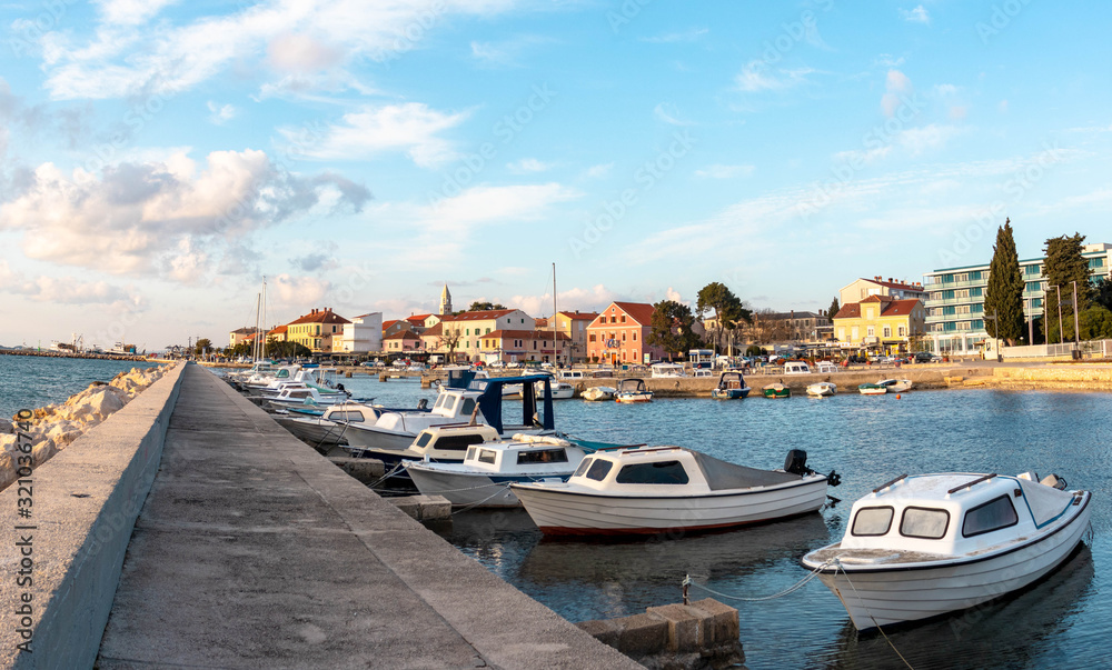 Small Dalmatian town of Biograd Na moru , Croatia. View of the sea and local small boats in marina. Sunny cloudy day Small Dalmatian town of Biograd Na moru , Croatia. View of the sea and local small boats in marina. Sunny cloudy day