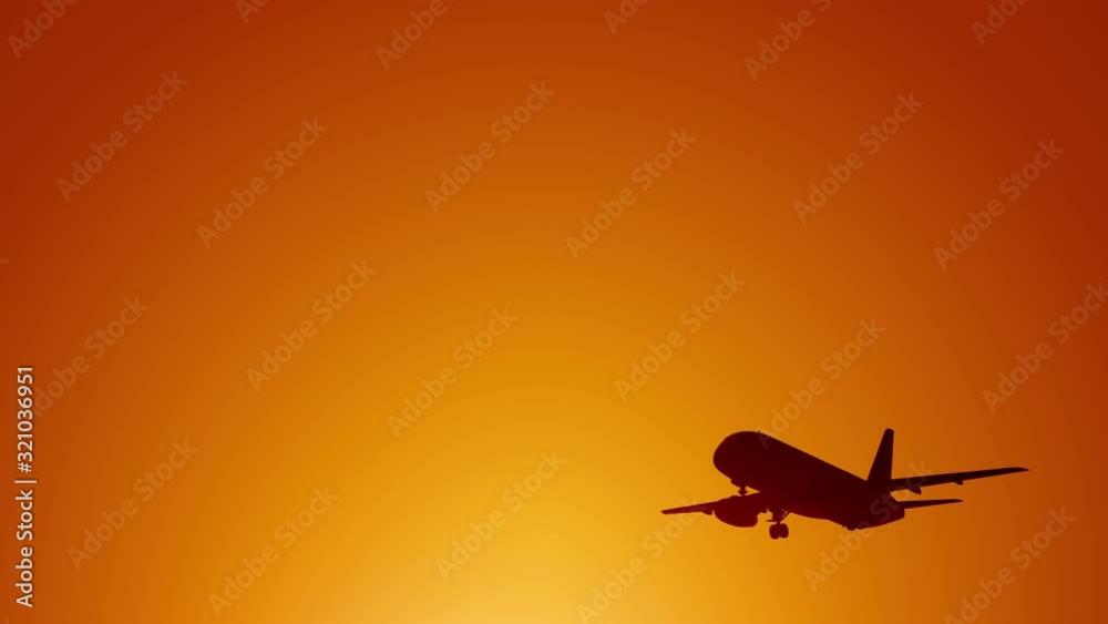 A large passenger plane takes off against the background of a sunset. Orange backgrand..Super slow motion.