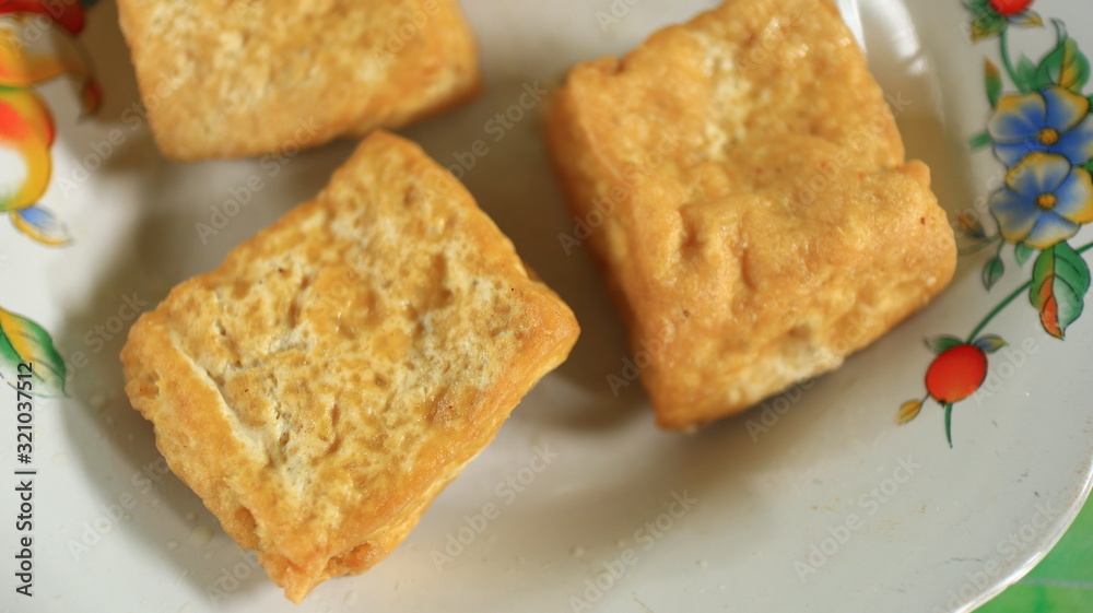 Blurred image out of focus fried tofu on a white plate, photographed with selective focus Blurred image out of focus fried tofu on a white plate, photographed with selective focus