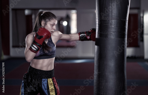 Young boxer girl hitting the heavy bag © Xalanx