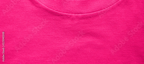 Pink shirt fabric texture with collar neck detail. Colorful vibrant pink color background, casual clothes material, blank plain t-shirt surface 