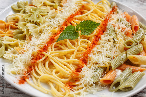 Different kinds of pasta in a white plate. Clous up photo