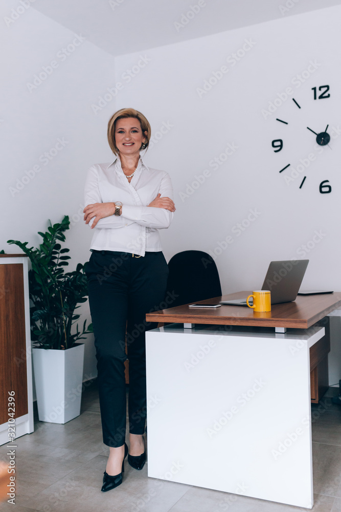 businesswoman standing arms crossed in her office businesswoman standing arms crossed in her office